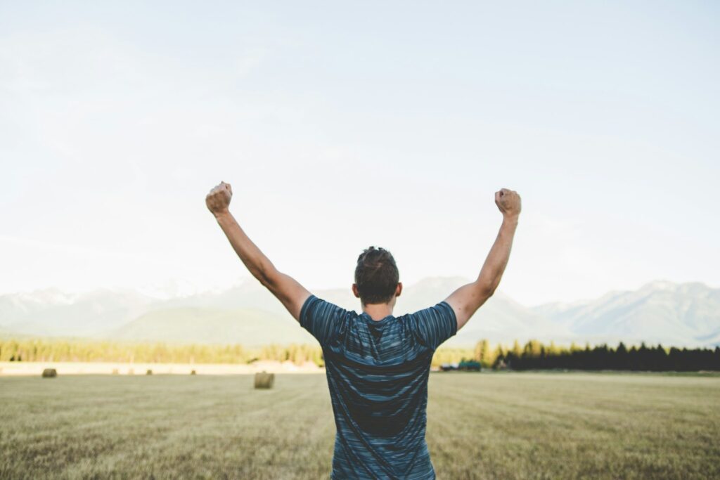 man reaching hands up high taken at daytime